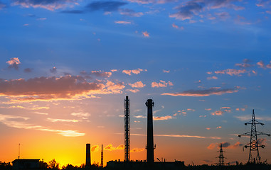 Image showing Industrial landscape with silhouettes of towers against the oran