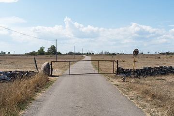 Image showing Gate by a country road in a dry grassland