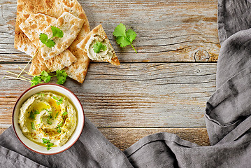 Image showing bowl of hummus on wooden table
