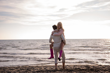 Image showing Loving young couple on a beach at autumn sunny day