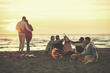 Image showing Couple enjoying with friends at sunset on the beach