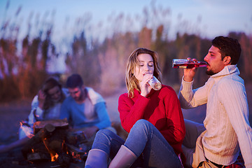 Image showing Couple enjoying with friends at sunset on the beach