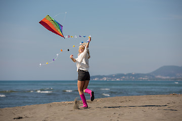 Image showing Young Woman with kite at beach on autumn day