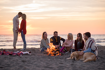 Image showing Couple enjoying with friends at sunset on the beach