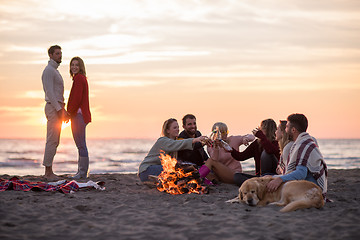 Image showing Couple enjoying with friends at sunset on the beach