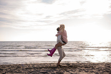 Image showing Loving young couple on a beach at autumn sunny day