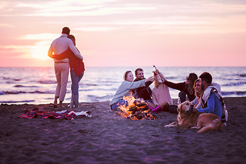 Image showing Couple enjoying with friends at sunset on the beach