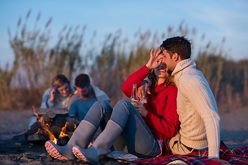 Image showing Couple enjoying with friends at sunset on the beach