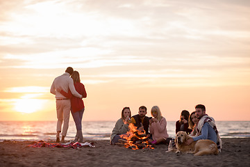 Image showing Couple enjoying with friends at sunset on the beach