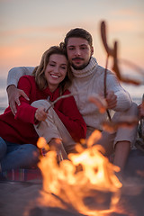 Image showing Group Of Young Friends Sitting By The Fire at beach