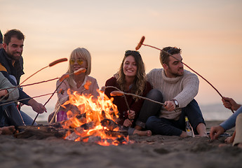 Image showing Group Of Young Friends Sitting By The Fire at beach