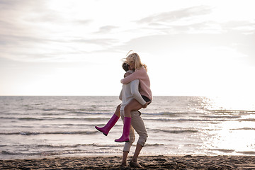 Image showing Loving young couple on a beach at autumn sunny day