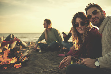 Image showing Couple enjoying with friends at sunset on the beach