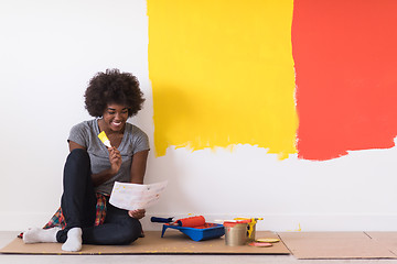 Image showing back female painter sitting on floor