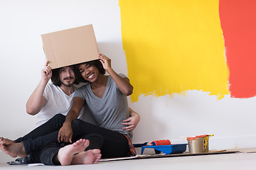 Image showing young multiethnic couple playing with cardboard boxes