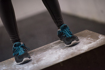 Image showing black woman is performing box jumps at gym