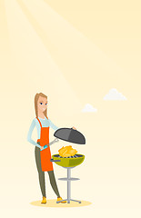 Image showing Woman cooking chicken on barbecue grill.