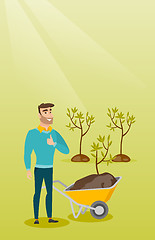 Image showing Man pushing wheelbarrow with plant.