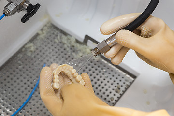 Image showing Dental Technician Cleans 3D Printed Dental Implant Bridge