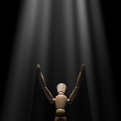 Image showing Wooden mannequin raised hands to light