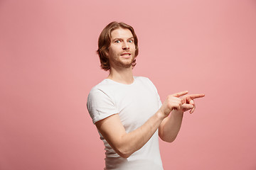 Image showing Suspiciont. Doubtful pensive man with thoughtful expression making choice against pink background