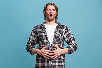 Image showing The happy business man standing and smiling against blue background.