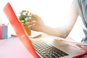 Image showing Woman working on computer in office and holding glasses