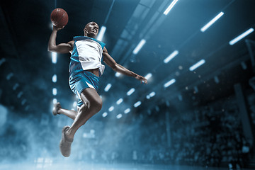 Image showing Basketball player on big professional arena during the game. Basketball player making slam dunk.