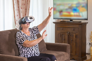 Image showing Senior woman with virtual headset or 3d glasses playing