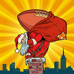 Image showing American football ball. Santa Claus with gifts climbs into the c