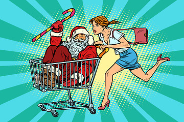 Image showing Christmas sale. The woman bought Santa Claus. shopping cart trol