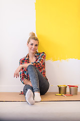 Image showing young female painter sitting on floor