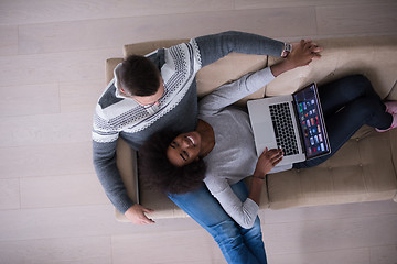 Image showing happy multiethnic couple relaxes in the living room