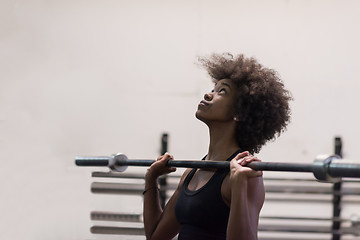 Image showing black woman lifting empty bar