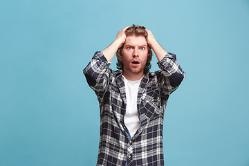 Image showing Beautiful man looking suprised and bewildered isolated on blue