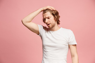 Image showing Beautiful man looking suprised and bewildered isolated on pink