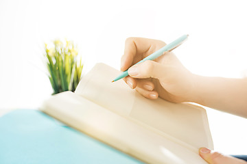 Image showing The male hands holding pen. The trendy blue desk.