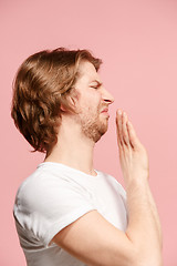 Image showing Young man with disgusted expression repulsing something, isolated on the pink