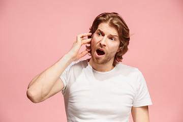 Image showing The Ear ache. The sad man with headache or pain on a pink studio background.