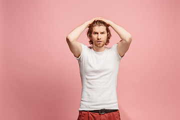 Image showing Beautiful man looking suprised and bewildered isolated on pink