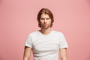 Image showing The serious business man standing and looking at camera against pink background.