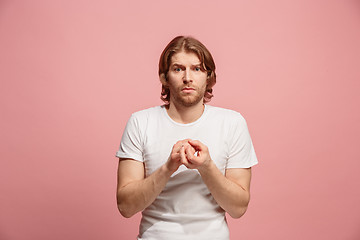 Image showing Let me think. Doubtful pensive man with thoughtful expression making choice against pink background