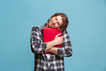 Image showing Businessman hugging laptop on blue