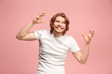 Image showing Portrait of an angry man looking at camera isolated on a pink background