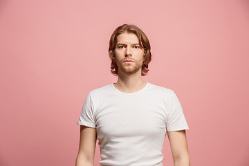 Image showing The serious business man standing and looking at camera against pink background.