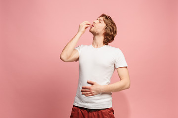 Image showing The happy business man standing and smiling against pink background.