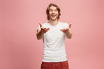 Image showing The happy business man standing and smiling against pink background.