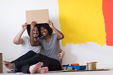 Image showing young multiethnic couple playing with cardboard boxes