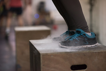 Image showing black woman is performing box jumps at gym