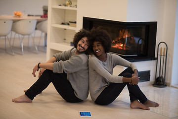 Image showing multiethnic couple with tablet computer on the floor